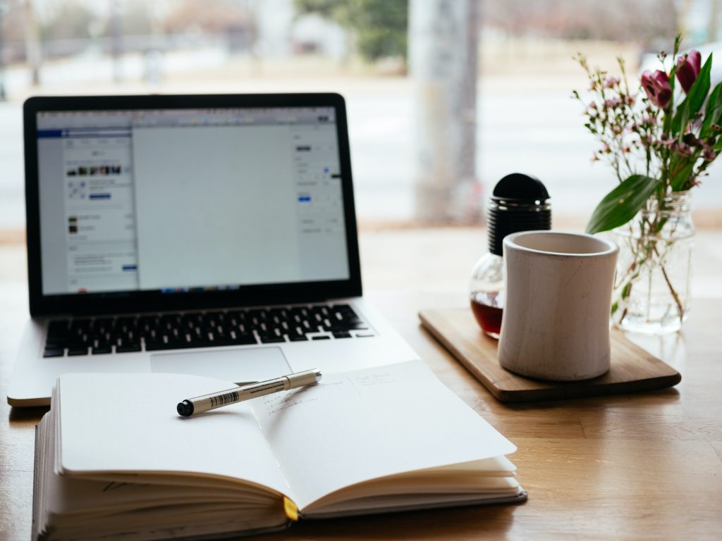 Image of pen and book in front of laptop